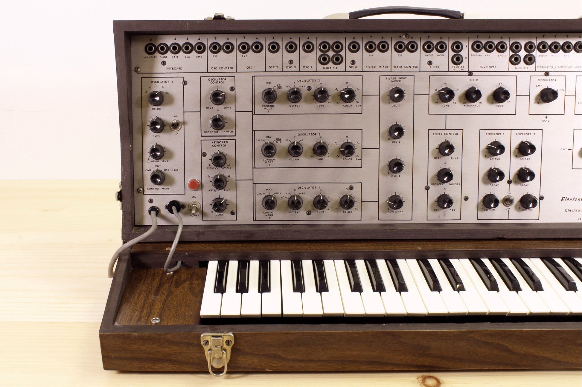 Vintage EML-101 semi-modular synthesizer with wooden casing on a light background