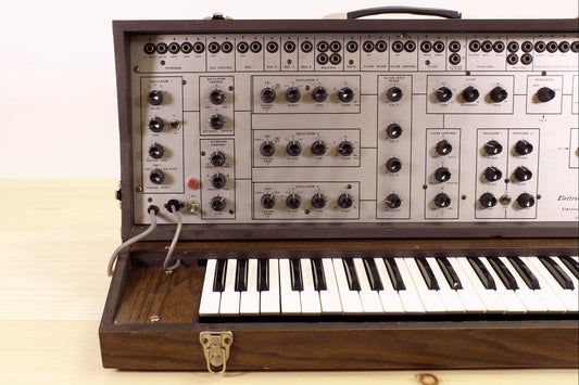 Vintage EML-101 semi-modular synthesizer with wooden casing on a light background