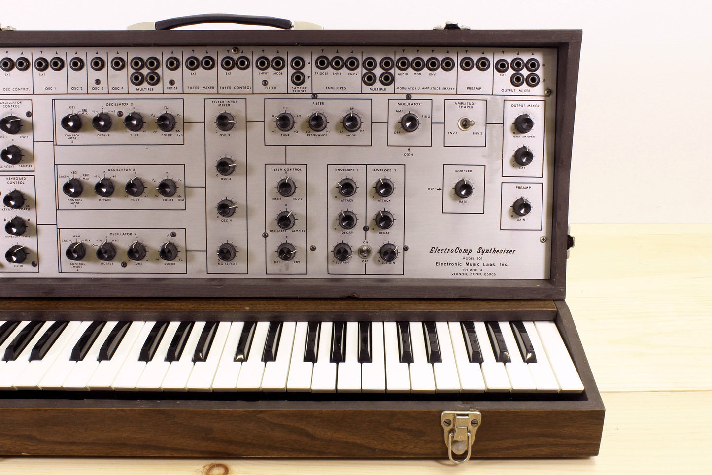 Vintage EML-101 synthesizer with keyboard on a wooden surface